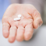 close up of senior woman hand with pills
