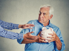 senior man grandfather holding piggy bank looking suspicious trying to protect his savings from being stolen