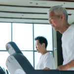 Old healthy Asian senior couple exercise together in gym running treadmill