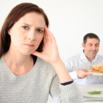 Young woman upset when her partner eat and enjoys carbohydrates