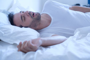 Man snoring because of apnea lying in the bed