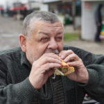 Portrait of Caucasian senior driver eating lyulya kebab in lavash