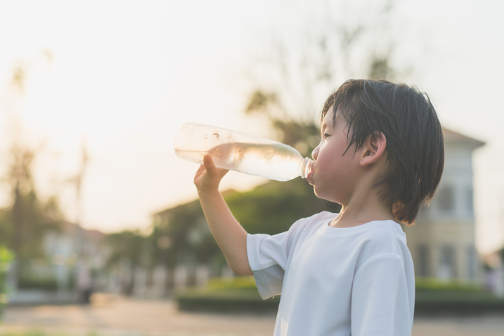 sian boy drinks water from a bottle