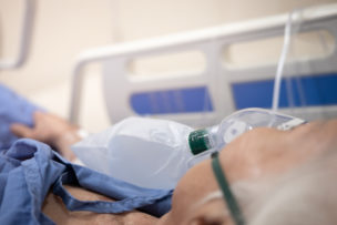 Oxygen mask on patient's face on the hospital bed