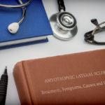 Titled book Amyotrophic Lateral Sclerosis along with medical equipment, conceptual image