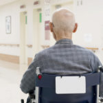Back view of old man sitting on wheelchair