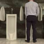 Man Peeing to Urinal in the Restroom