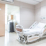 Hospital patient ward or ICU intensive care unit blur background with blurry medical empty bed room interior for nursing care and health treatment service backdrop