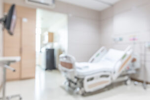 Hospital patient ward or ICU intensive care unit blur background with blurry medical empty bed room interior for nursing care and health treatment service backdrop