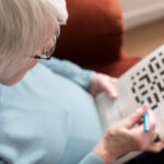 Senior Woman Doing Crossword Puzzle At Home