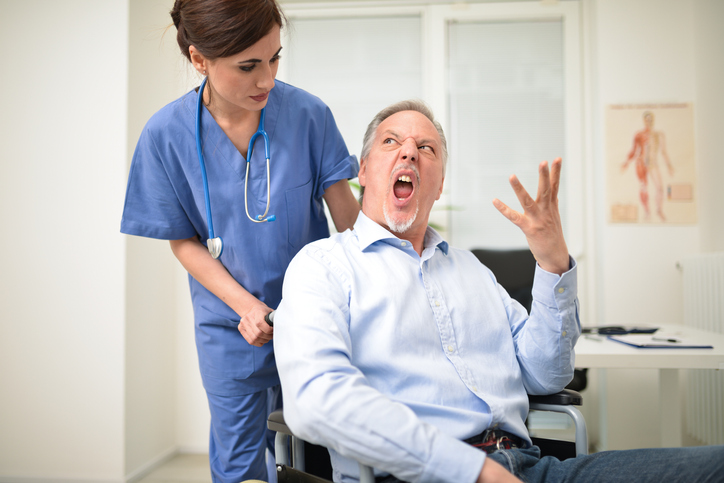 Angry disabled patient and a nurse
