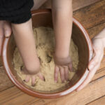 Parent and child hand mixing rice bran pickles