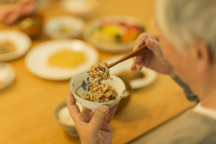 Senior man eating natto at dinner