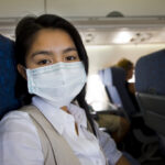 woman with protective mask in a plane