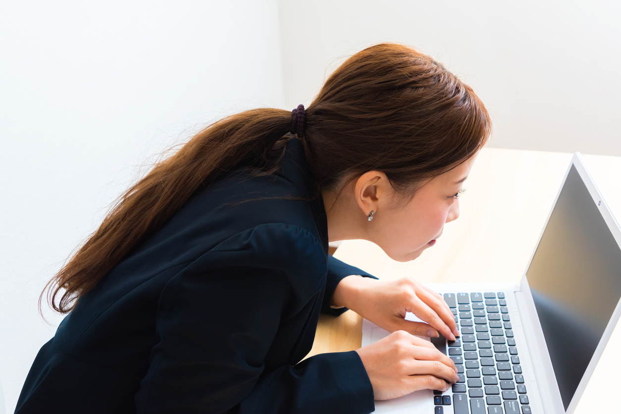 Image of woman using laptop while sitting at her desk