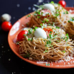 Buckwheat noodles with quail eggs, tomatoes and microgreen. Selective focus.