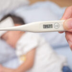 Fever, Close-up medical thermometer, Parent / Father measuring temperature of his ill kid, Asian 3 - 4 years old toddler boy gets high fever