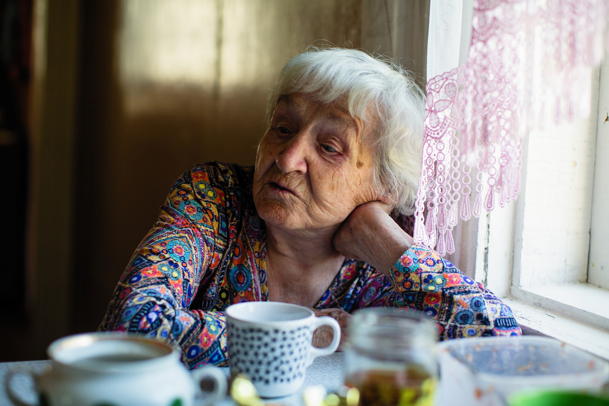 Portrait of an elderly russian woman sitting in the kitchen.