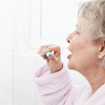 profile of senior woman brushing teeth