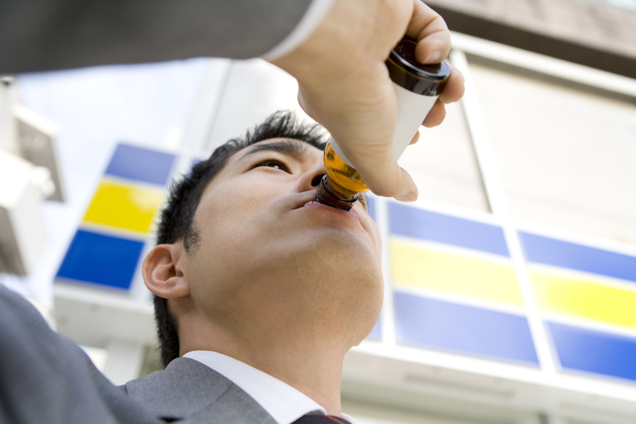 Man drinking energy drink in front of convenience store