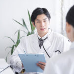 A Japanese male doctor examining a female office worker
